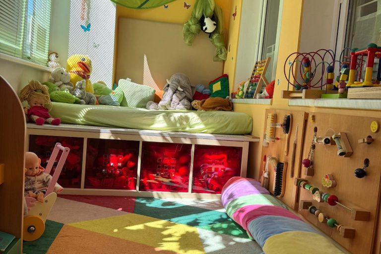 Relax Lounge, Liegewiese Bunte Kinderzimmer mit Spielzeug, Bett, Teppich und interaktiver Wandgestaltung.