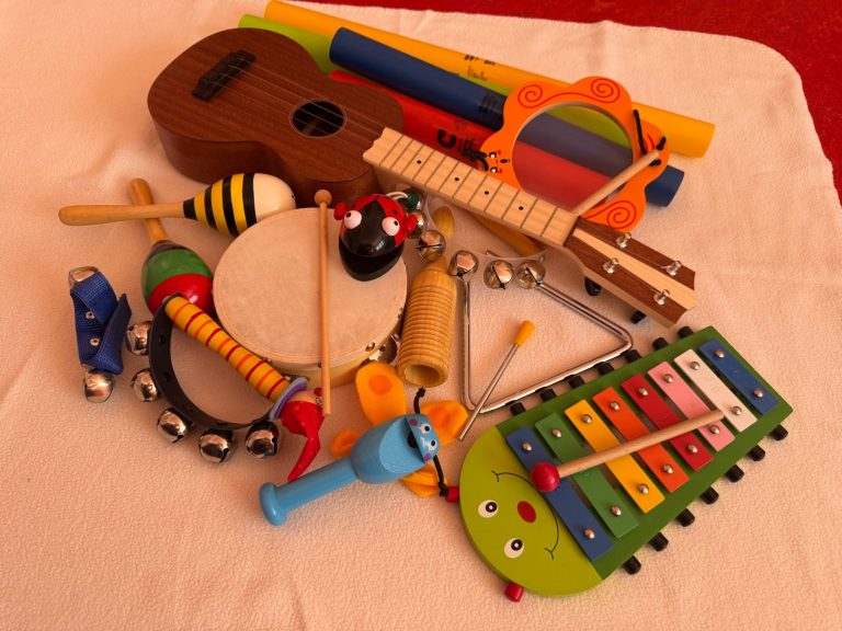 Bunte Musikinstrumente, darunter eine Ukulele, Tamburin und Xylophon.