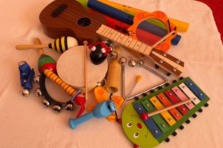 Kreativ, Musik, Tanzen, Lachen Bunte Spielzeuginstrumente, einschließlich Ukulele, Xylophon und Rasseln.